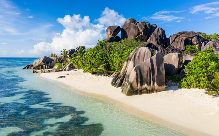 Tourist on a beautiful beach with white sand on a tropical island in the Seychelles - The famous beach of Anse d'Argent in La Digue